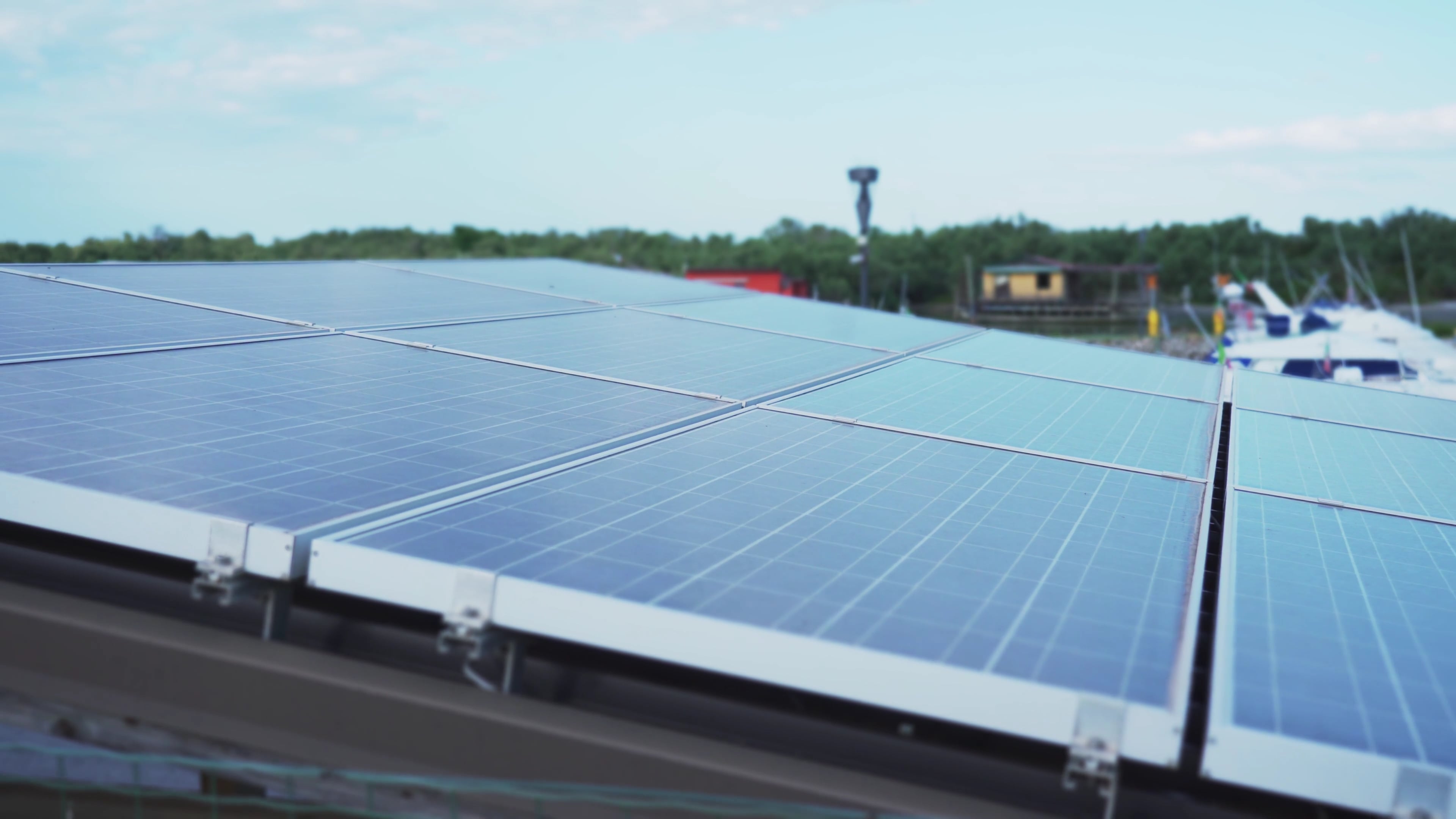 Installer setting a black solar panel on a shingled roof